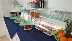 A buffet setup with various food items, including pastries, cereal, and fruits. - Hotel Daisy (San Giovanni Lupatoto)