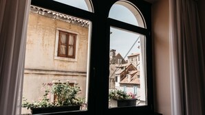 A window with a view of a building with a tiled roof and a window with a wooden frame. - Abokamento Boutique Rooms (Split)
