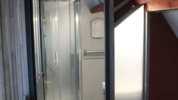 A glass-enclosed shower area with a curved design, a wooden floor, and a metal frame structure.
