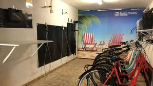 A bike rental station with multiple bicycles, a wall-mounted bike rack, and a beach-themed mural in the background. - Fornaci 2 - 2-4 people 100 meters from the sea (Pietra Ligure)