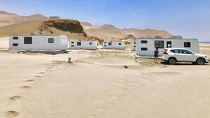 A caravan park with multiple caravans and a white car parked in the foreground.