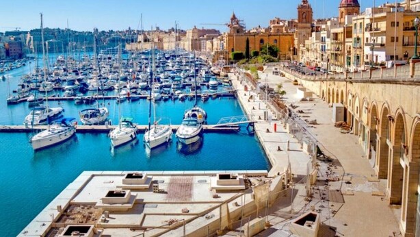A marina with numerous boats docked, a waterfront promenade, and historic buildings in the background. - Historic Townhouse in Birgu Center (Il-Birgu)