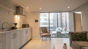 A modern kitchen with a built-in microwave, a coffee machine, and a large window overlooking a cityscape. - 1 BR Beautiful New Apartment in Bocagrande (Cartagena)