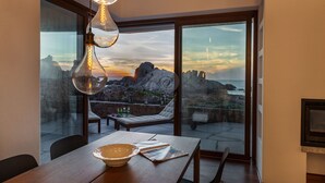 En matplats med utsikt över klippiga branter och havet vid solnedgången.