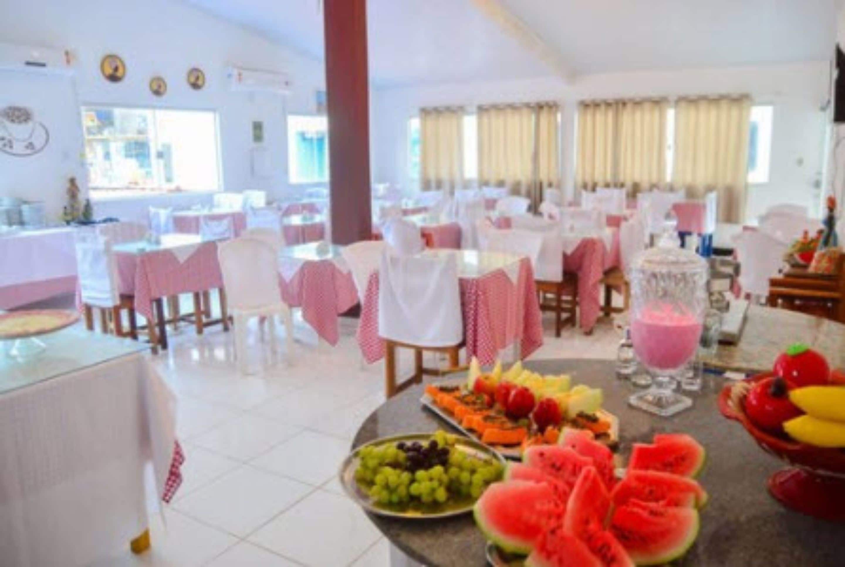 A dining area with round tables covered in white tablecloths, arranged in rows.