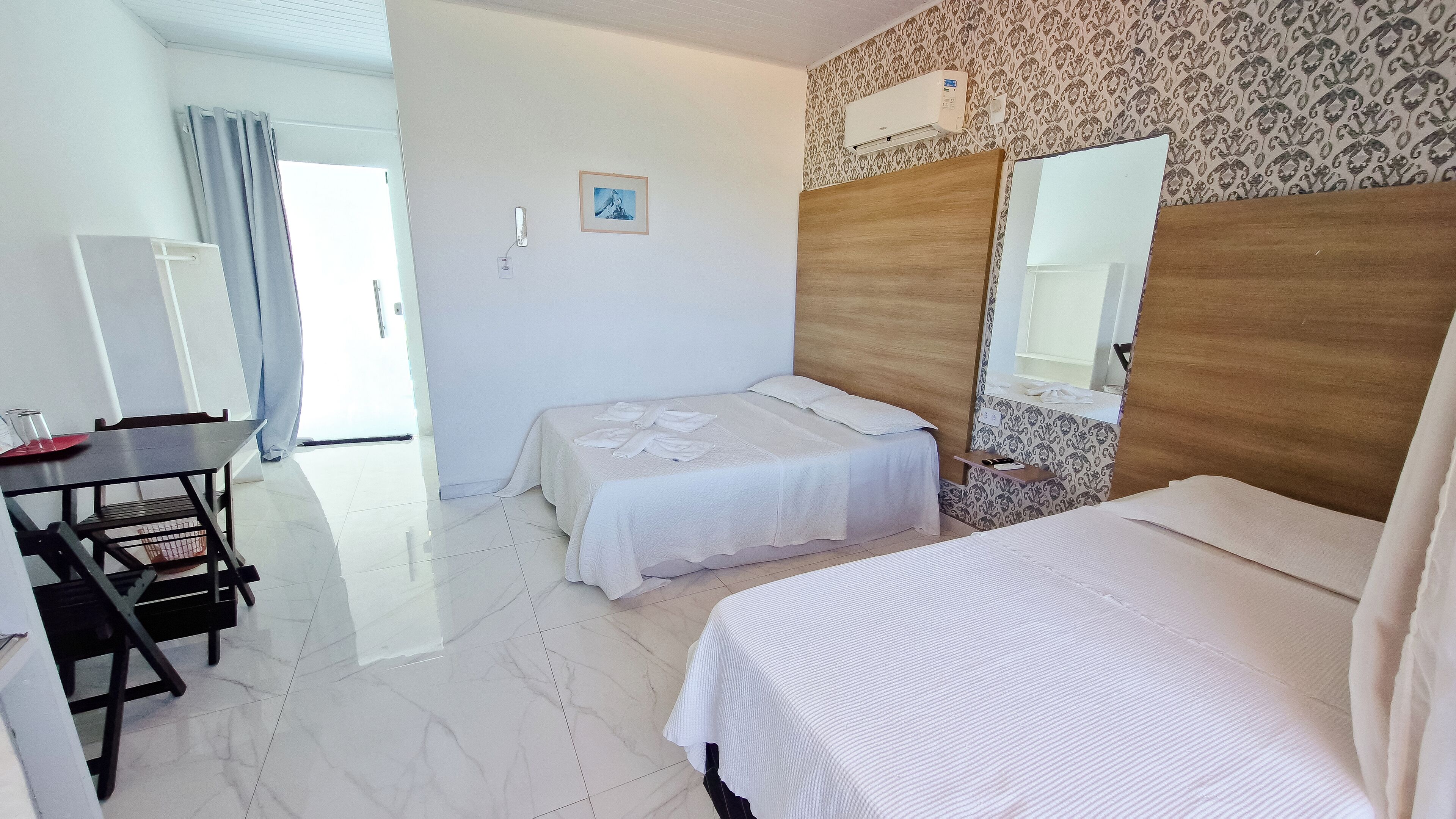 Una habitación de hotel con dos camas, un escritorio y una silla.