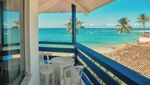 Un balcon avec vue sur l’océan et les palmiers.