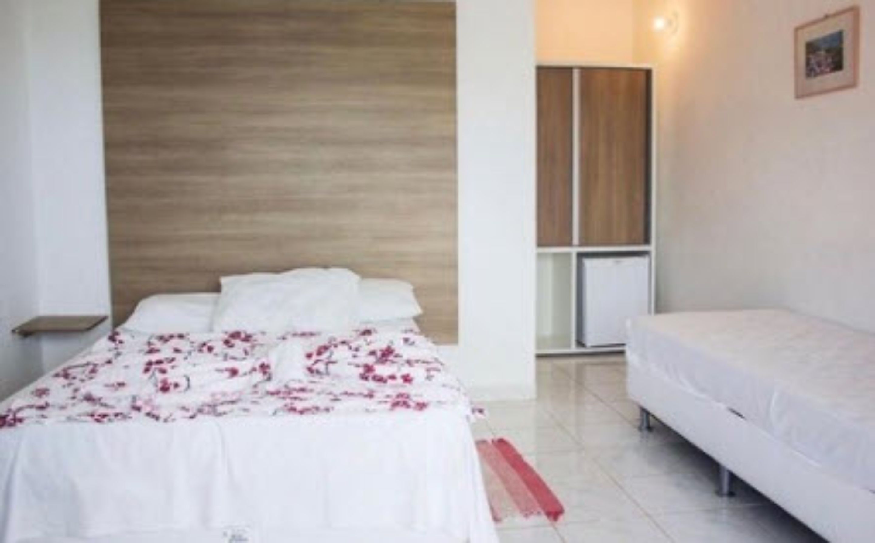 Un dormitorio con cama, mesita de noche, cómoda y ventana.