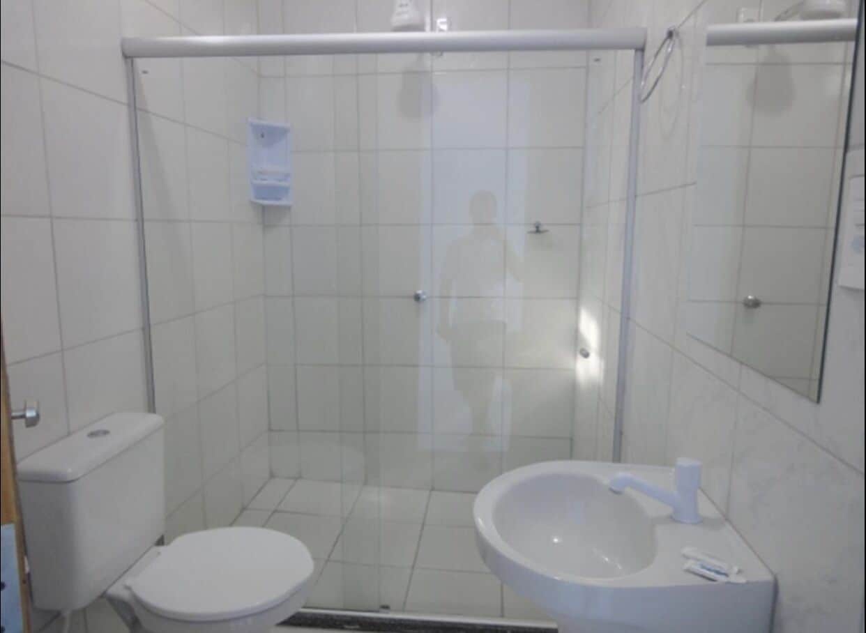 A small, enclosed shower stall with a toilet and sink.