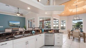 A modern kitchen with white cabinets, a granite countertop, and a built-in dishwasher.