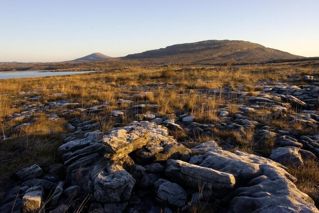 A rocky landscape with a body of water and hills in the background.