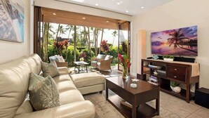 A modern living room with a beige sofa, a coffee table, and a TV on a wooden stand. - Aloha Villas # 4, Luxury Oceanfront Townhouse, Ste (Kihei)