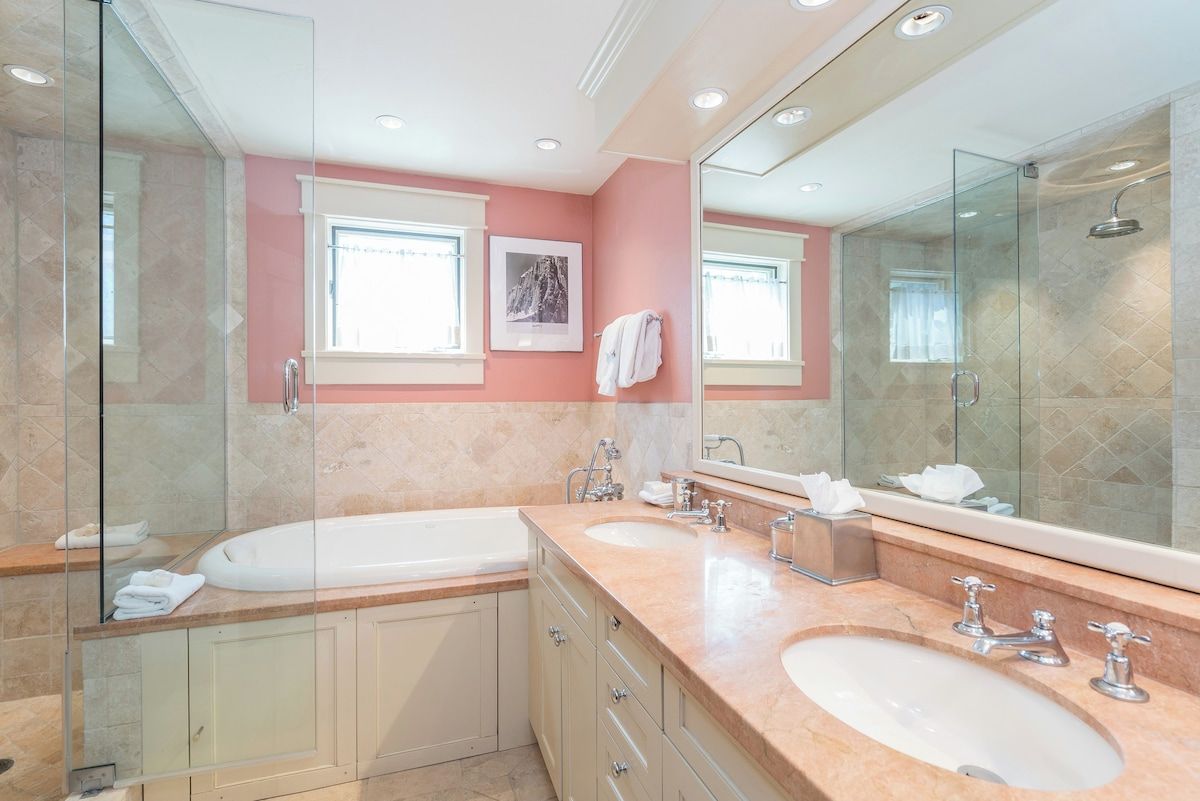 Un baño moderno con lavamanos doble, un espejo grande y cabina de ducha con paredes de vidrio.