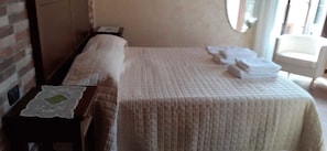 A hotel room with a bed, a nightstand, a chair, and a window. - B&B Rivellini (Tropea)