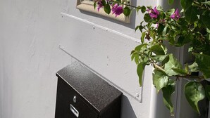 A house number 327 on a white wall, with a mailbox and a window in the background. - Tiana Beach Hotel (Hollywood)