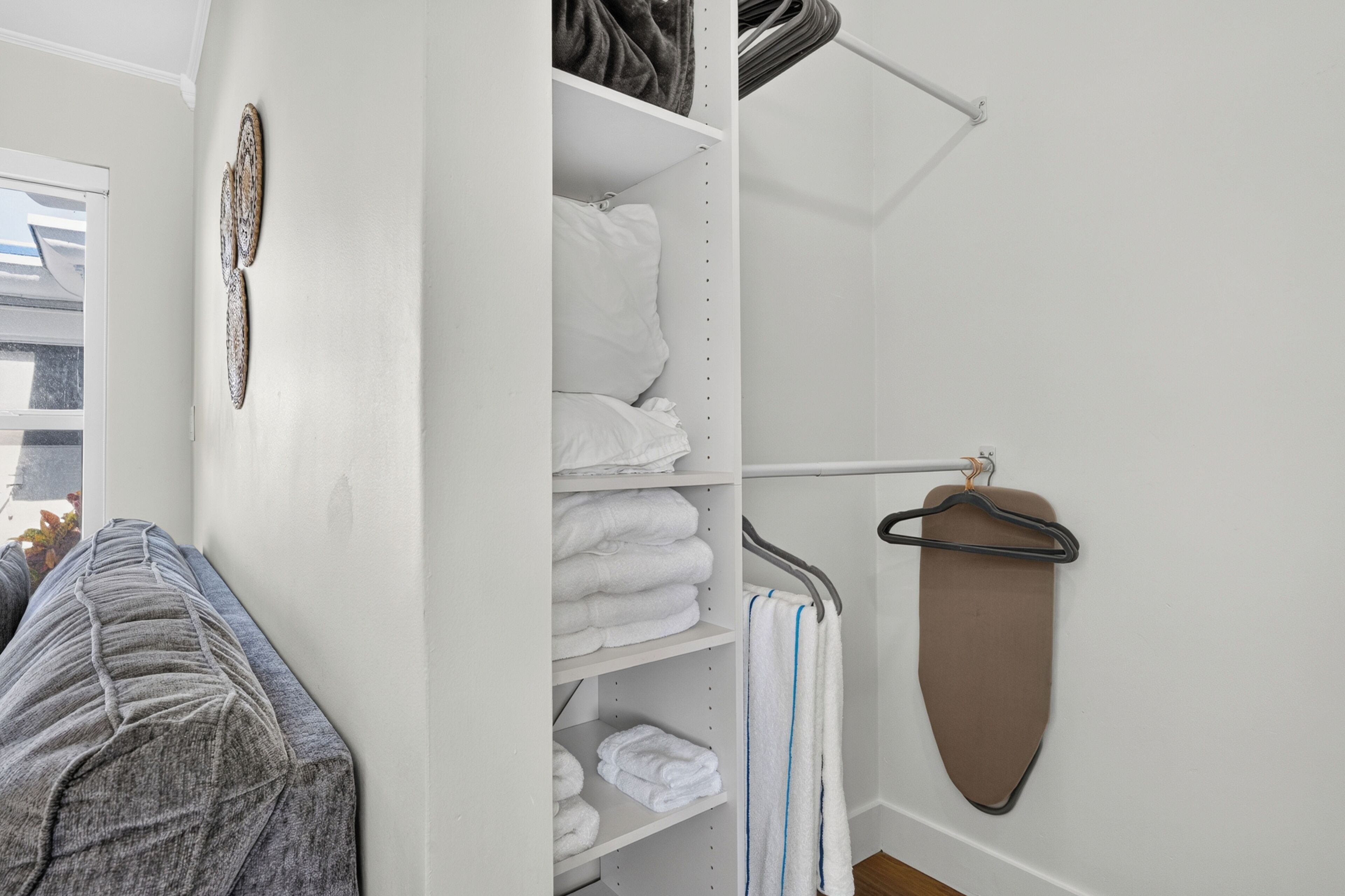 Um guarda-roupa bem arrumado, com prateleiras para roupas dobradas e cabideiro para peças penduradas.