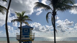 A lifeguard tower on a beach with palm trees and a clear sky. - Tiana Beach Hotel (Hollywood)