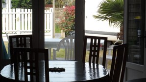 A round table with four chairs, a white fence, and a potted plant in the background. - Rest Sea Sun comfort at 600m beach (la plaine sur mer Tharon plage)