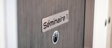 Una puerta de madera con un letrero que dice "Séminaire 1" y el símbolo de accesibilidad para sillas de ruedas.