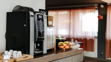 A kitchenette with a coffee maker, a microwave, and a fruit bowl on the counter.