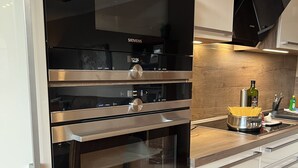 Een keuken met een Siemens oven, een houten aanrecht en een roestvrijstalen pan.