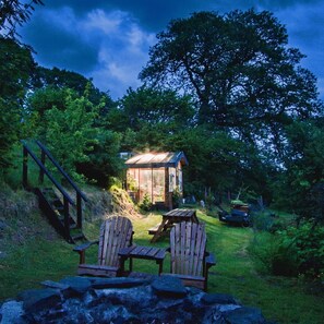 A cabin with a wooden deck, two Adirondack chairs, and a staircase leading up to it. - Hapus Yurt - Two Beautiful Yurts and Barn Cottage (Abergele)