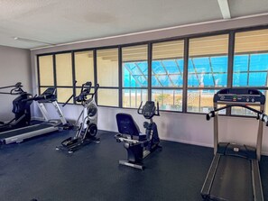 Un gimnasio con cintas de correr, elípticas y bicicletas estáticas.
