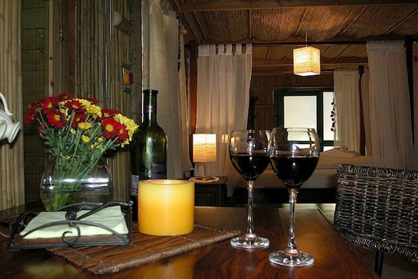A wooden table with a candle, a vase of flowers, and two wine glasses. - Biktapuz & Klemantina - Adults Only (Mateh Asher)
