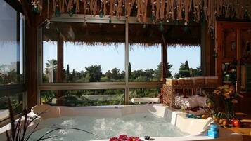 A hot tub with a view of a garden and trees.