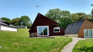 En modern byggnad med ett sluttande tak, stora fönster och en synlig satellitparabol.