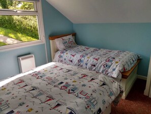 Ein Schlafzimmer mit Bett, Fenster und Heizkörper.