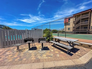 An outdoor patio area with a barbecue grill, a table, and a bench. - Inlet Point Villas 2A (North Myrtle Beach)