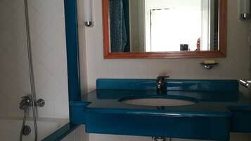 Een bad/douchecombinatie, een haardroger, toiletpapier