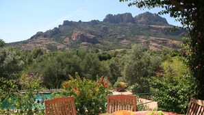 A dining table set outdoors with a mountain view in the background. - rent large family villa near the sea and nature (Roquebrune-Sur-Argens)