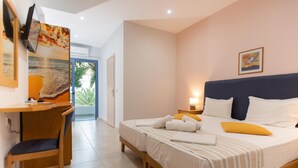 A hotel room with a bed, a desk, and a chair. - Neos Ikaros (Agios Vasileios)