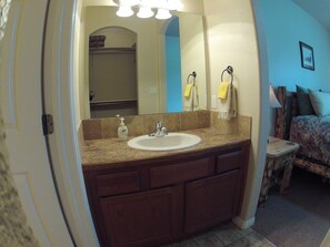 Een bad/douchecombinatie, een haardroger, handdoeken