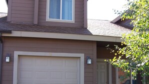 A two-story house with a garage, a front door, and a small porch. - Close to Tamarack and Cascade Lake boat ramps (Donnelly)