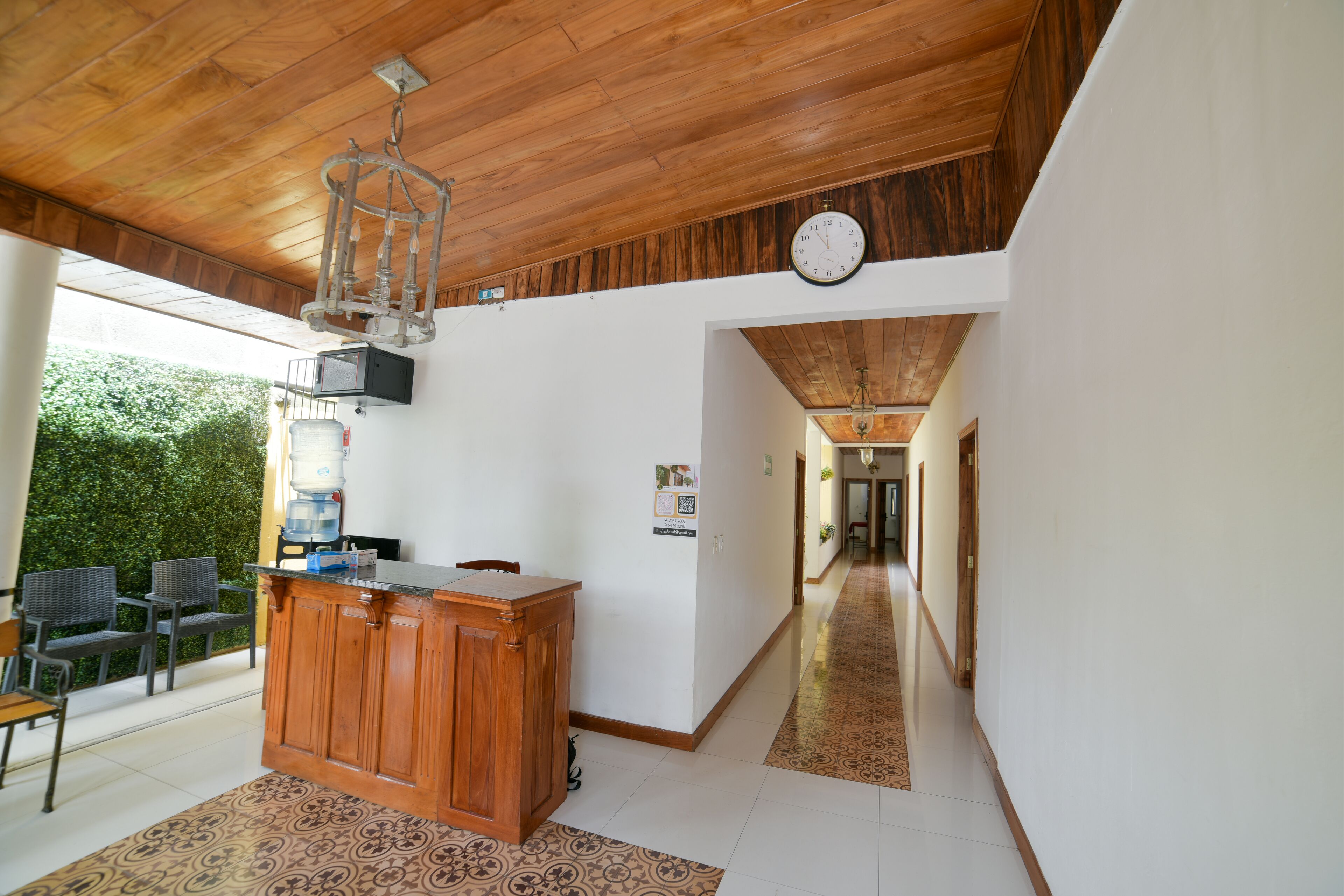 A spacious kitchen with a wooden ceiling, a built-in bar counter, and a clock on the wall.