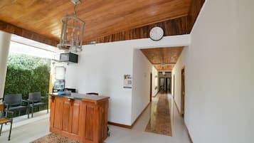 A spacious kitchen with a wooden ceiling, a built-in bar counter, and a clock on the wall.