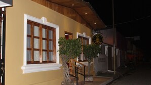 Ein Gebäude mit gelber Fassade, Holzverkleidung und einem Schild mit einem Ananas-Logo.