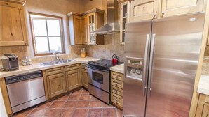 A kitchen with wooden cabinets, a stainless steel refrigerator, a dishwasher, and a stove. - Luxury Guesthouse w Views, Private Sauna & Hot Tub- 30 day minimum. (Santa Fe)