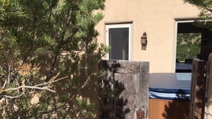 A wooden gate, a door, and a pool area in front of a building with a beige exterior. - Luxury Guesthouse w Views, Private Sauna & Hot Tub- 30 day minimum. (Santa Fe)