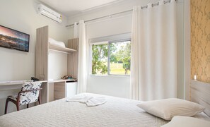 Minibar, escritorio, cortinas blackout y tabla de planchar con plancha 
