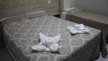 Ein Hotelzimmer mit zwei Betten, jeweils mit gemusterten Bettbezügen.