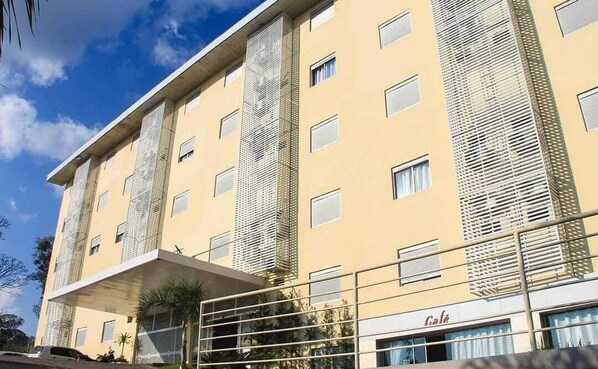 A multi-story hotel with a flat facade, large windows, and a visible entrance with a metal gate.