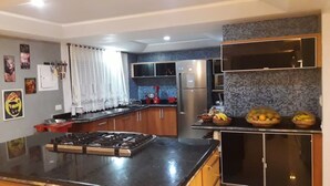 Una cocina moderna con estufa a gas, electrodomésticos de acero inoxidable y salpicadero de azulejos.