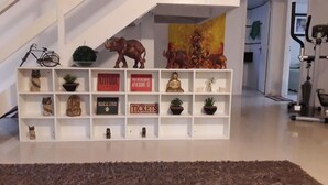Un estante blanco con diversos objetos decorativos, como figuritas, plantas y letreros con frases motivacionales.