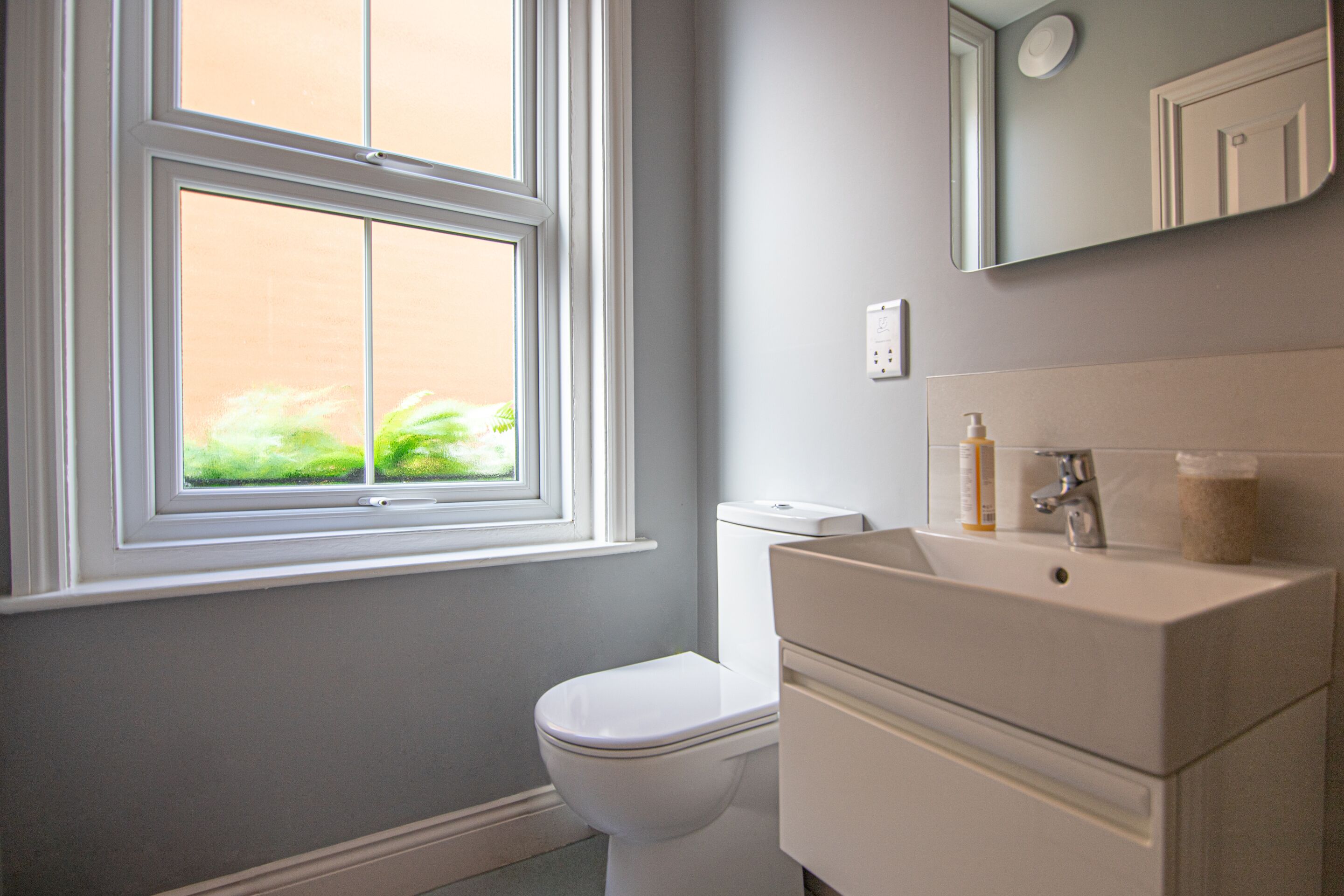 Un baño con inodoro, lavamanos y ventana.