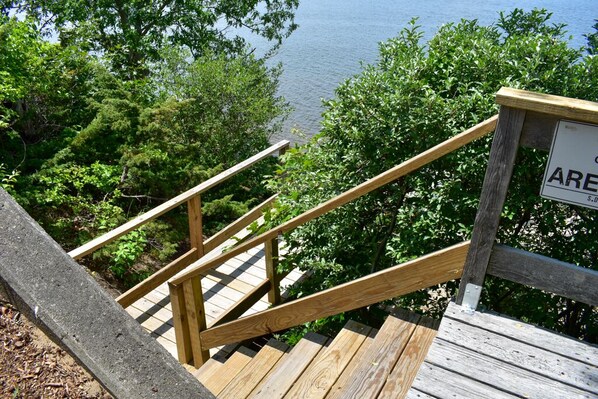 A wooden staircase leading to a viewing platform with a sign that reads "ARE". - Amazing pond views and unforgettable sunsets from all levels! (Dennis Port)