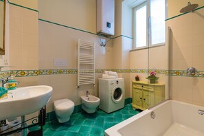 Tina con regadera, secadora de cabello, bidet, toallas 